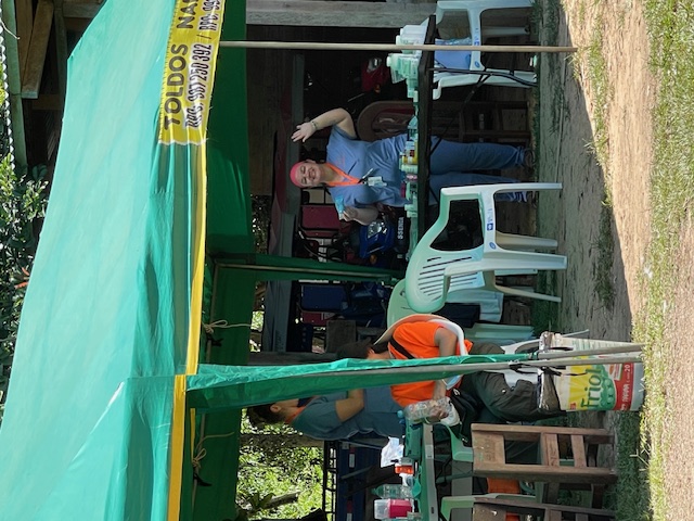 Pine Point Medical team member waving while volunteering at an outdoor medical clinic in a remote community.