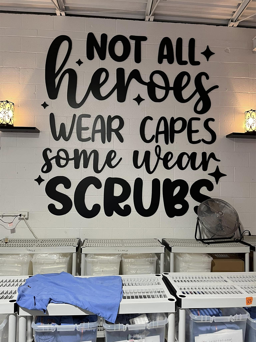 Wall mural reading 'Not all heroes wear capes, some wear scrubs' at International Medical Relief warehouse.