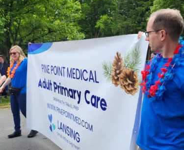 Pine Point Medical staff carrying banner at Dryden Dairy Parade community event